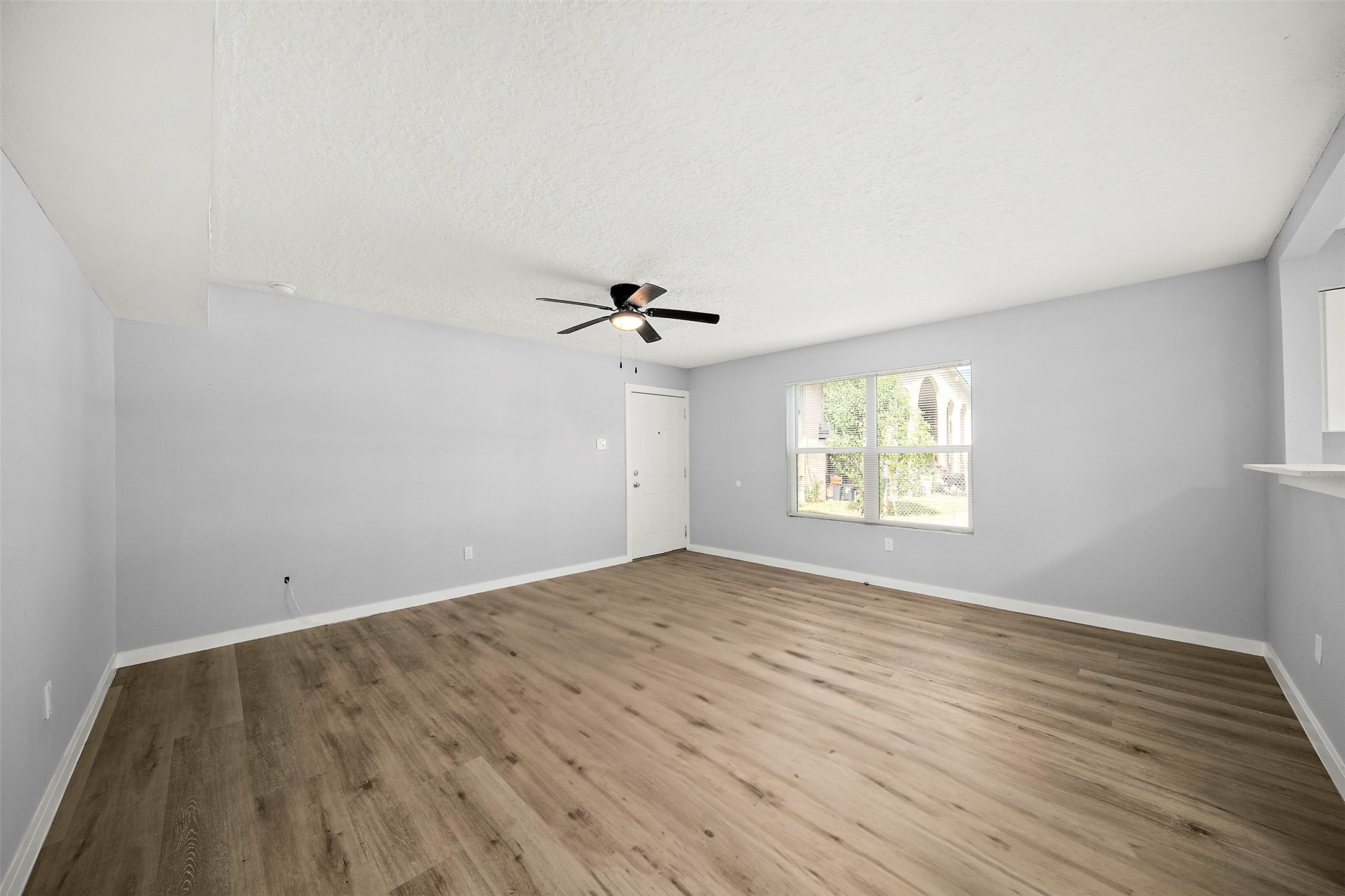 16415 Woodrow Street, Unit 24 Channelview, TX 77530 - Photo 2 of 11 wooden floor in an empty room with a window