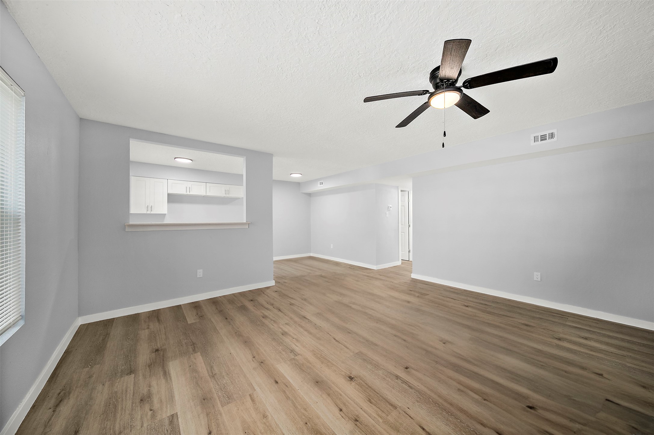 16415 Woodrow Street, Unit 24 Channelview, TX 77530 - Photo 3 of 11 wooden floor in an empty room with a window