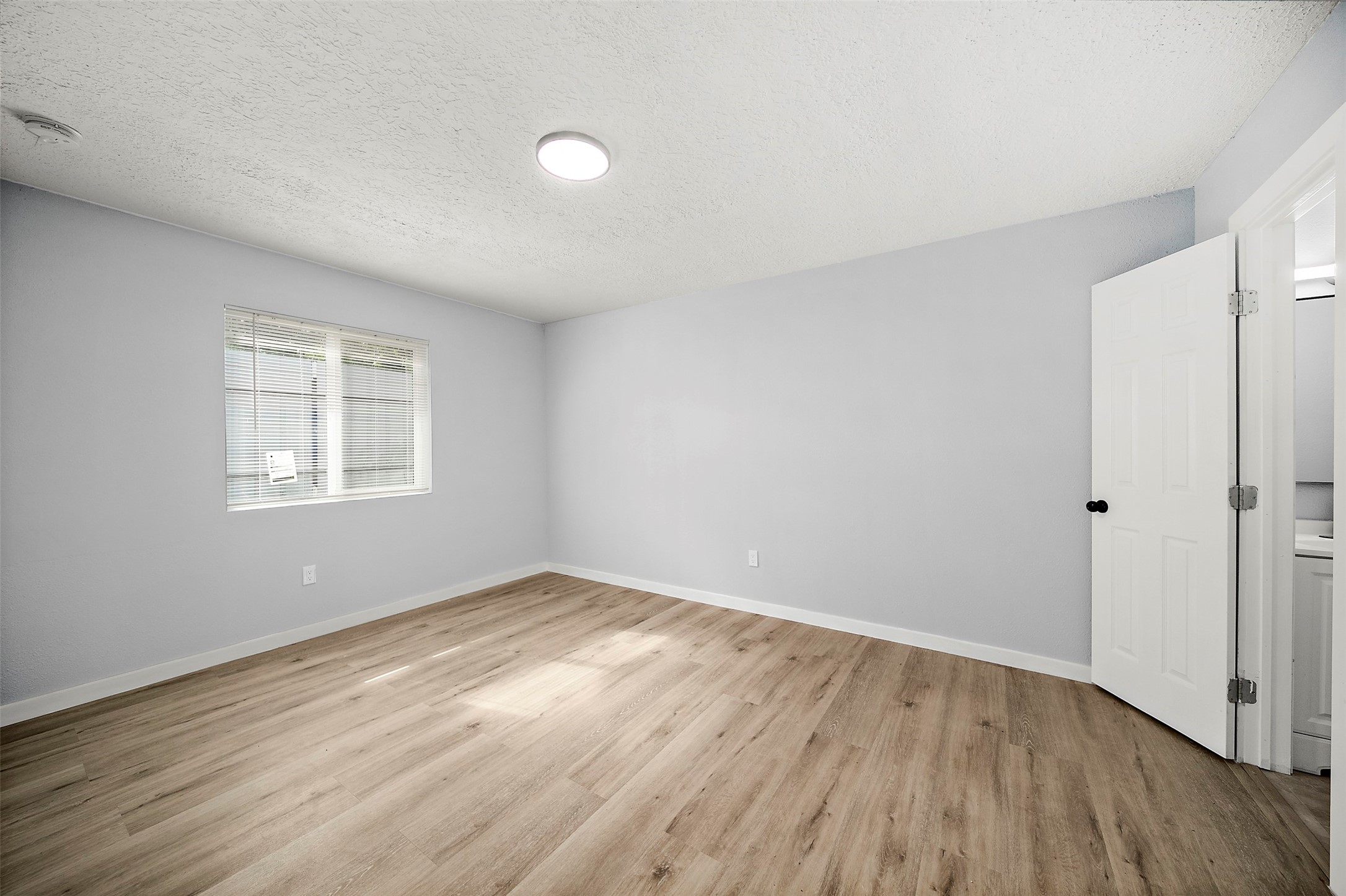 16415 Woodrow Street, Unit 24 Channelview, TX 77530 - Photo 5 of 11 an empty room with wooden floor and windows