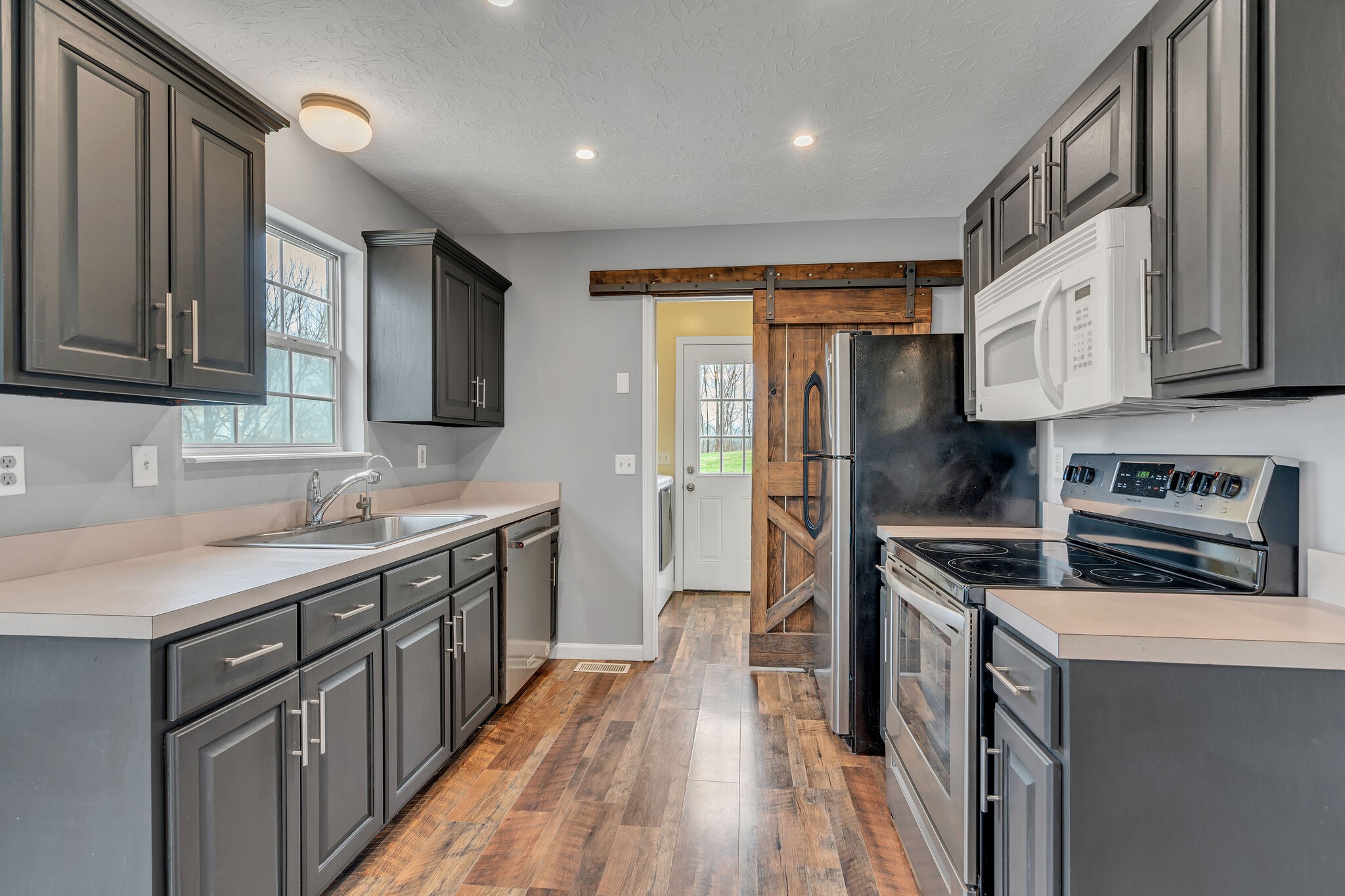 3716 Dobbin Road Springfield, TN 37172 - Photo 13 of 34 a kitchen with stainless steel appliances granite countertop a refrigerator a sink dishwasher a stove and white countertops with wooden floor