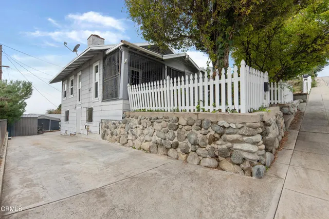 a view of a house with a wooden fence