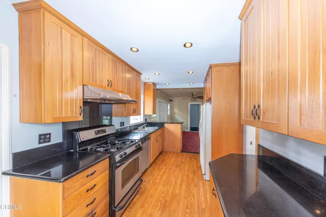 a kitchen with stainless steel appliances granite countertop a stove a sink and a refrigerator