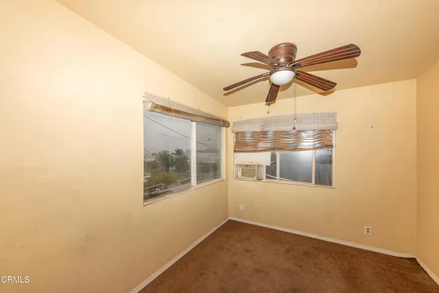 a view of a room with a ceiling fan and a window
