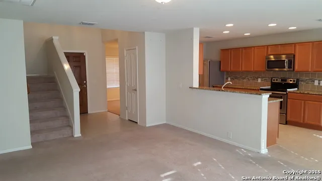 a view of a kitchen with fridge and wooden floor