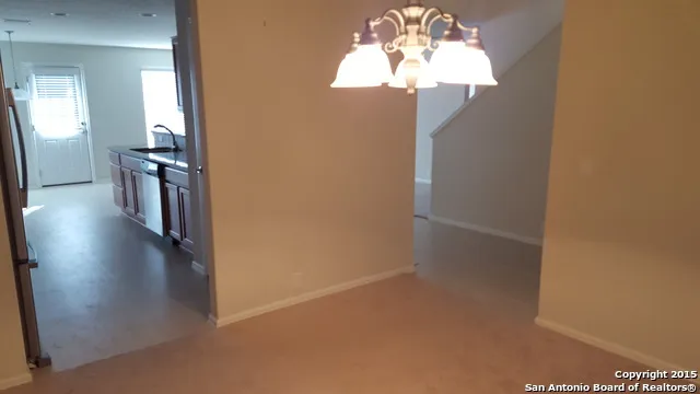 a view of a hallway with wooden floor and a chandelier