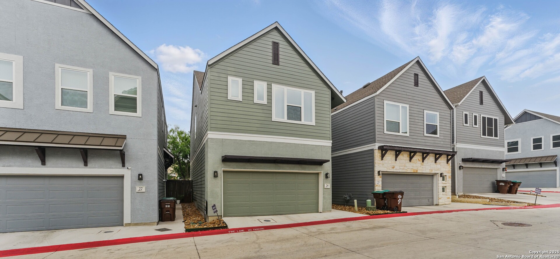 a front view of a house with a road and plants