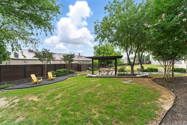 a view of a backyard with table and chairs and a fire pit