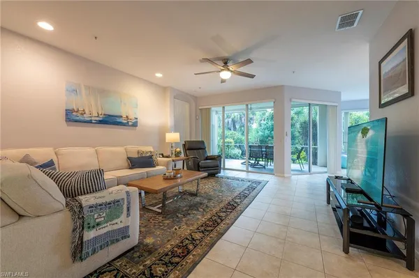 a living room with furniture a large window and flat screen tv