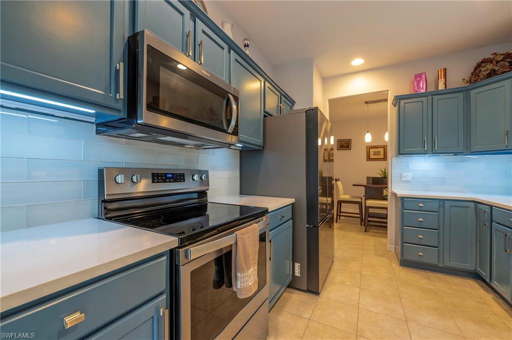 4675 Winged Foot Court, Unit 102 Naples, FL 34114 - Photo 15 of 31 a kitchen with stainless steel appliances a stove a microwave and cabinets