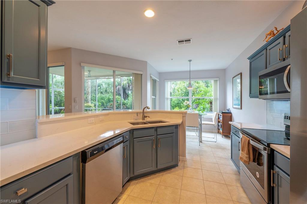 4675 Winged Foot Court, Unit 102 Naples, FL 34114 - Photo 18 of 31 a kitchen with a sink and large window