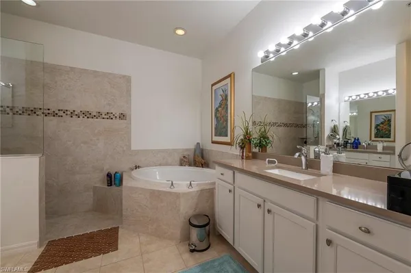 a bathroom with a double vanity sink a large mirror and shower