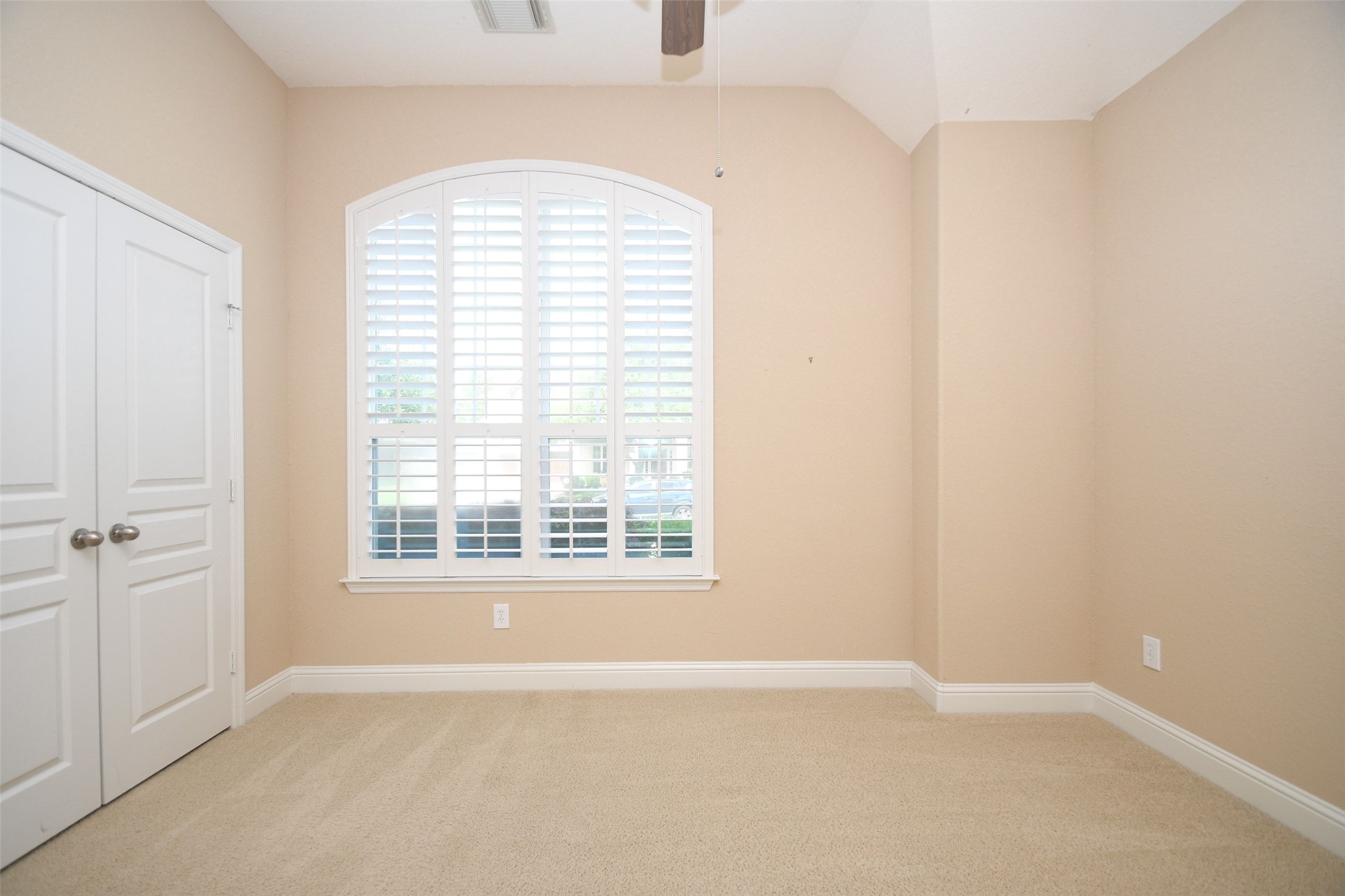 5803 Oakdale Meadows Spring, TX 77379 - Photo 4 of 21 This room features soft beige walls, a plush carpet, and a large window with plantation shutters, allowing natural light to fill the space. Dual doors suggest a closet, adding functionality. Perfect as a bedroom or home office.