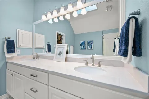 a bathroom with a sink a large mirror and a light fixture