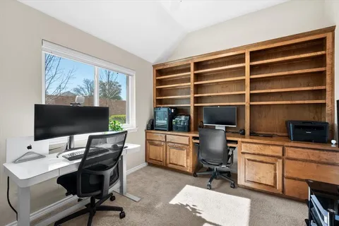 a view of a workspace with furniture and a window