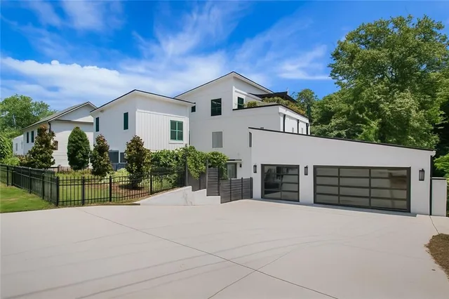 a view of a house with a fence and a tree