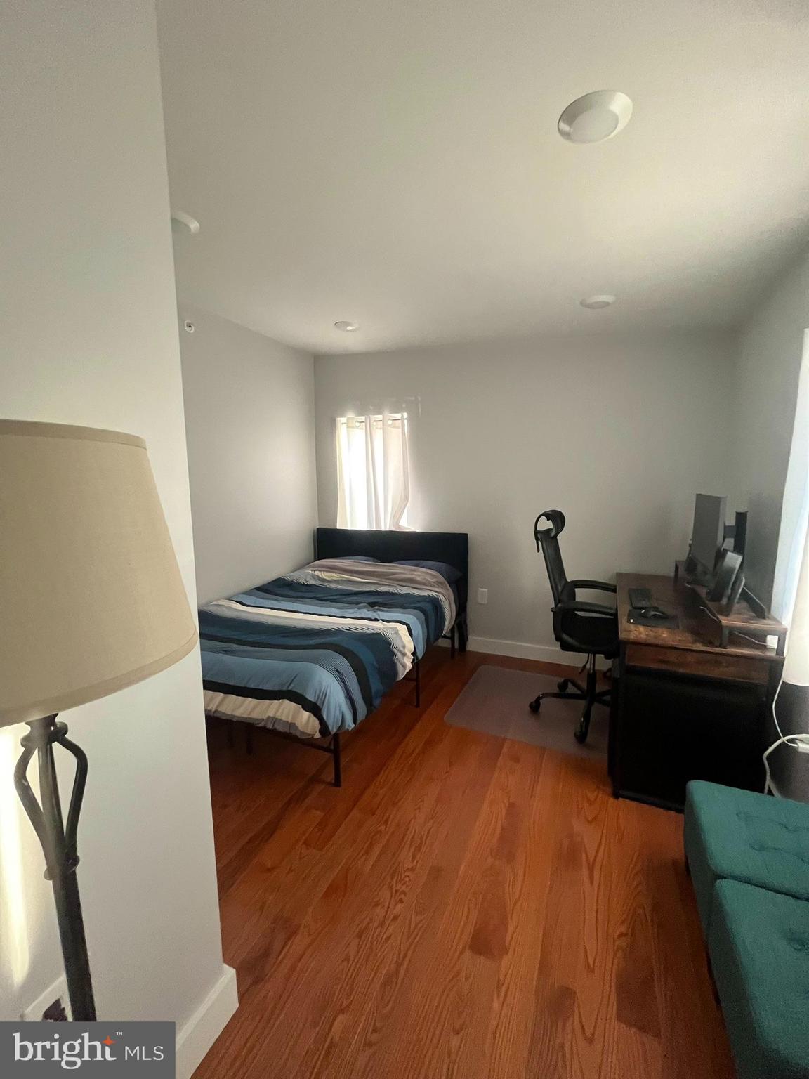 4508 Walnut Street, Unit 404 Philadelphia, PA 19139 - Photo 11 of 18 a bedroom with furniture and a wooden floor