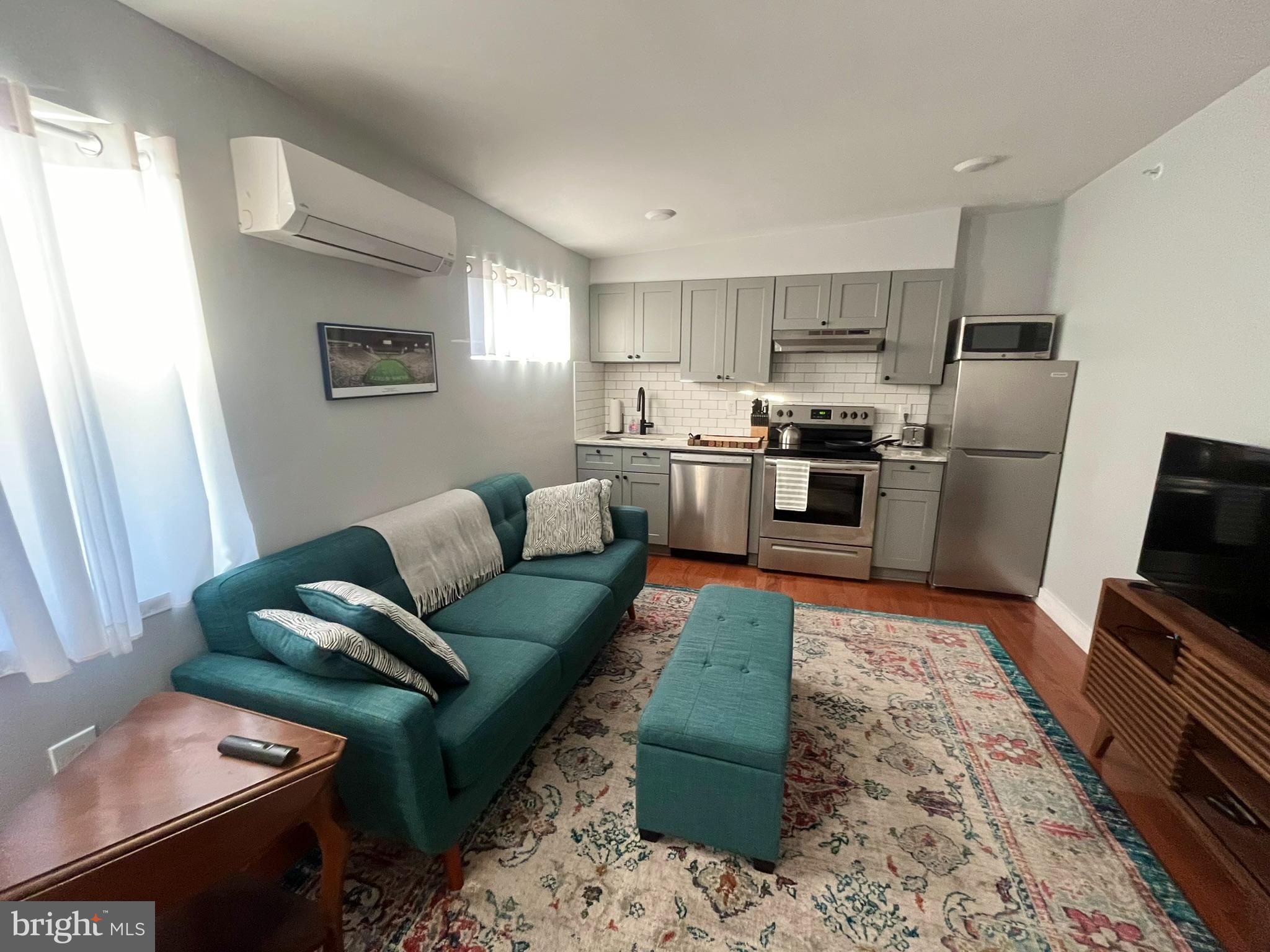 4508 Walnut Street, Unit 404 Philadelphia, PA 19139 - Photo 3 of 18 a living room with stainless steel appliances furniture windows and a kitchen view