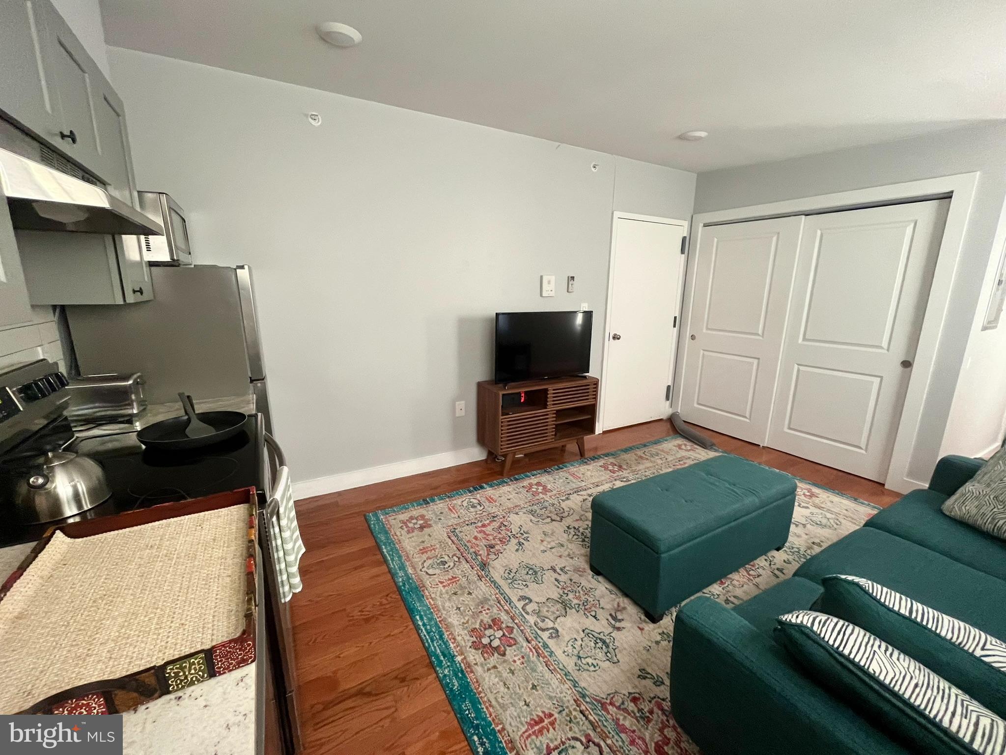 4508 Walnut Street, Unit 404 Philadelphia, PA 19139 - Photo 6 of 18 a living room with furniture and a flat screen tv