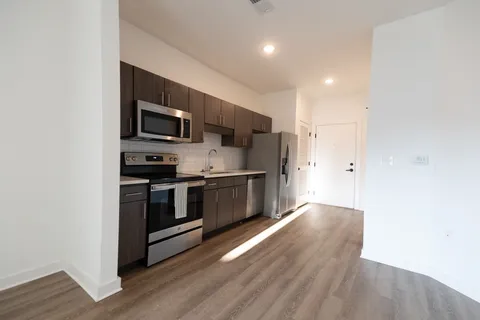 a kitchen with stainless steel appliances a stove a microwave and a hard wood floors