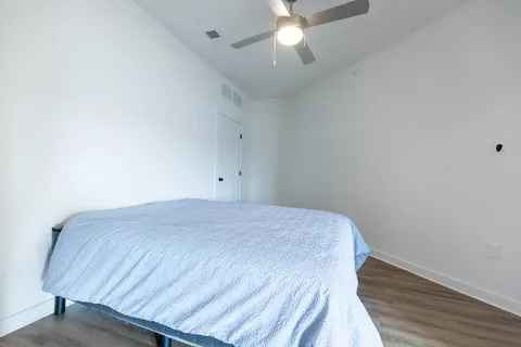 a bedroom with a bed and a chandelier fan