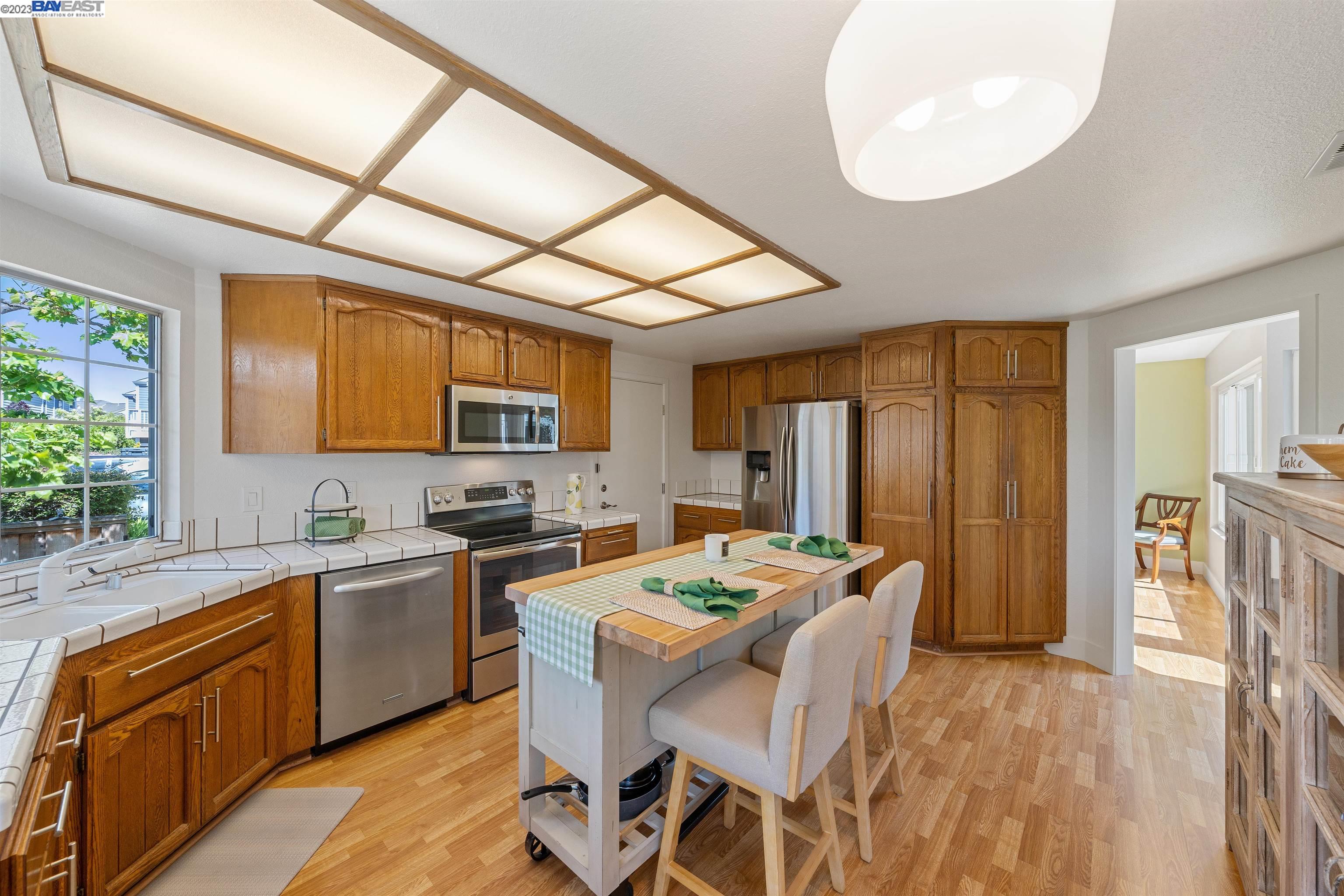 Undisclosed Address Alameda, CA 94502 - Photo 22 of 44 a kitchen with a table chairs refrigerator and microwave