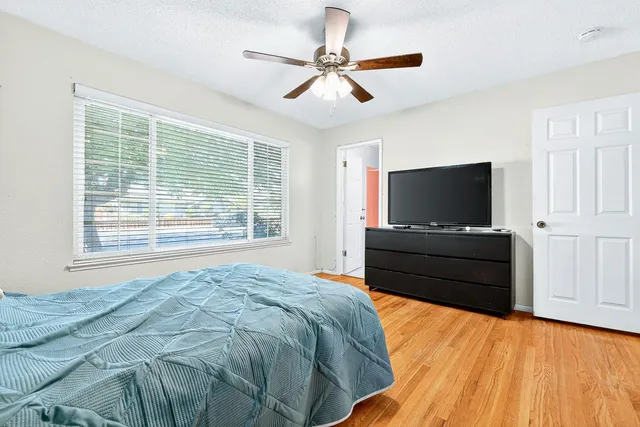 a bedroom with a bed flat screen tv and a window
