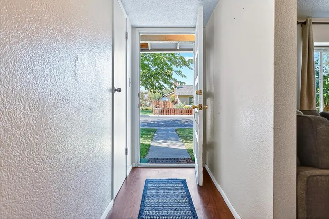 a view of hallway with wooden floor and a carpet