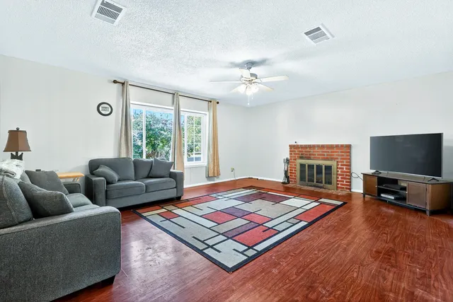 a living room with furniture flat screen tv and a large window