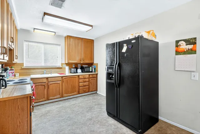 a kitchen with stainless steel appliances granite countertop a refrigerator and a sink