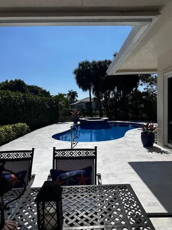 a view of a patio with table and chairs with wooden floor and fence