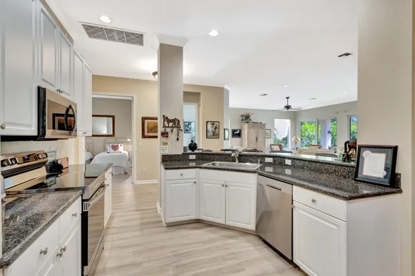 a living room with patio furniture and a view of kitchen