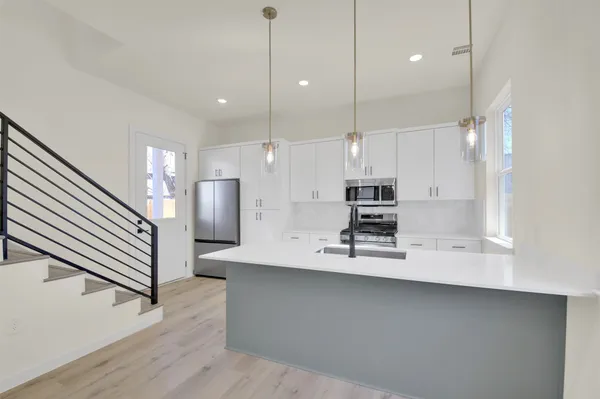 a large kitchen with kitchen island a sink stainless steel appliances and a counter top