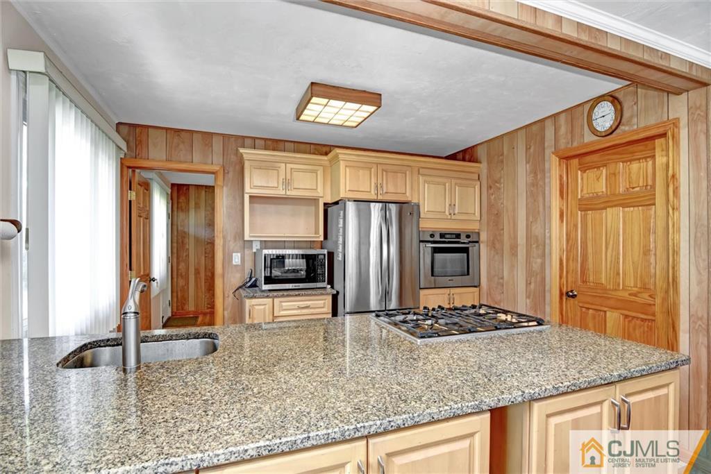 17 Brandeis Road Old Bridge, NJ 08859 - Photo 12 of 30 a kitchen with stainless steel appliances granite countertop a sink stove and refrigerator