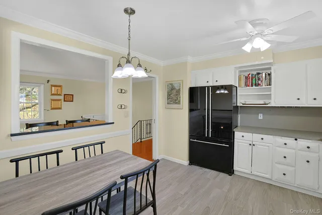 a kitchen with granite countertop a refrigerator a stove a sink cabinets and a dining table