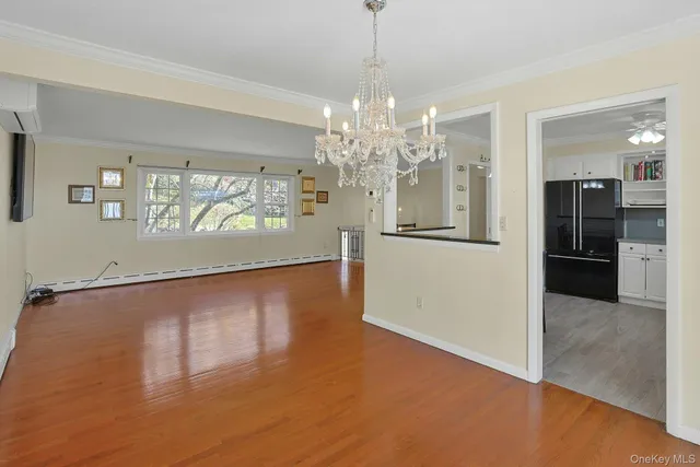 a view of a big room with windows and chandelier