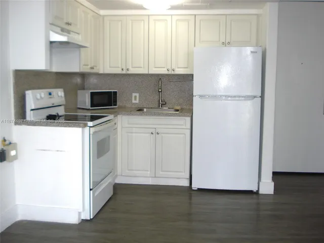 a kitchen with a refrigerator sink and cabinets