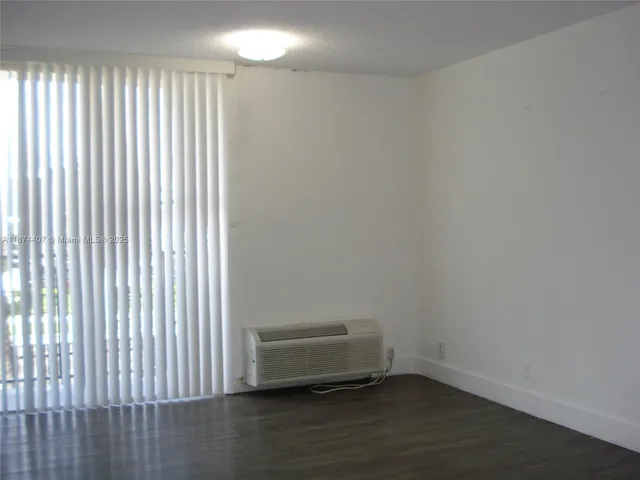 a view of a room with wooden floor and a window