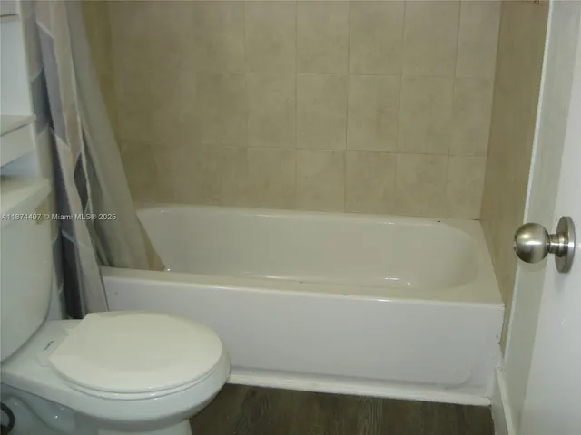 a bathroom with a toilet and a bath tub