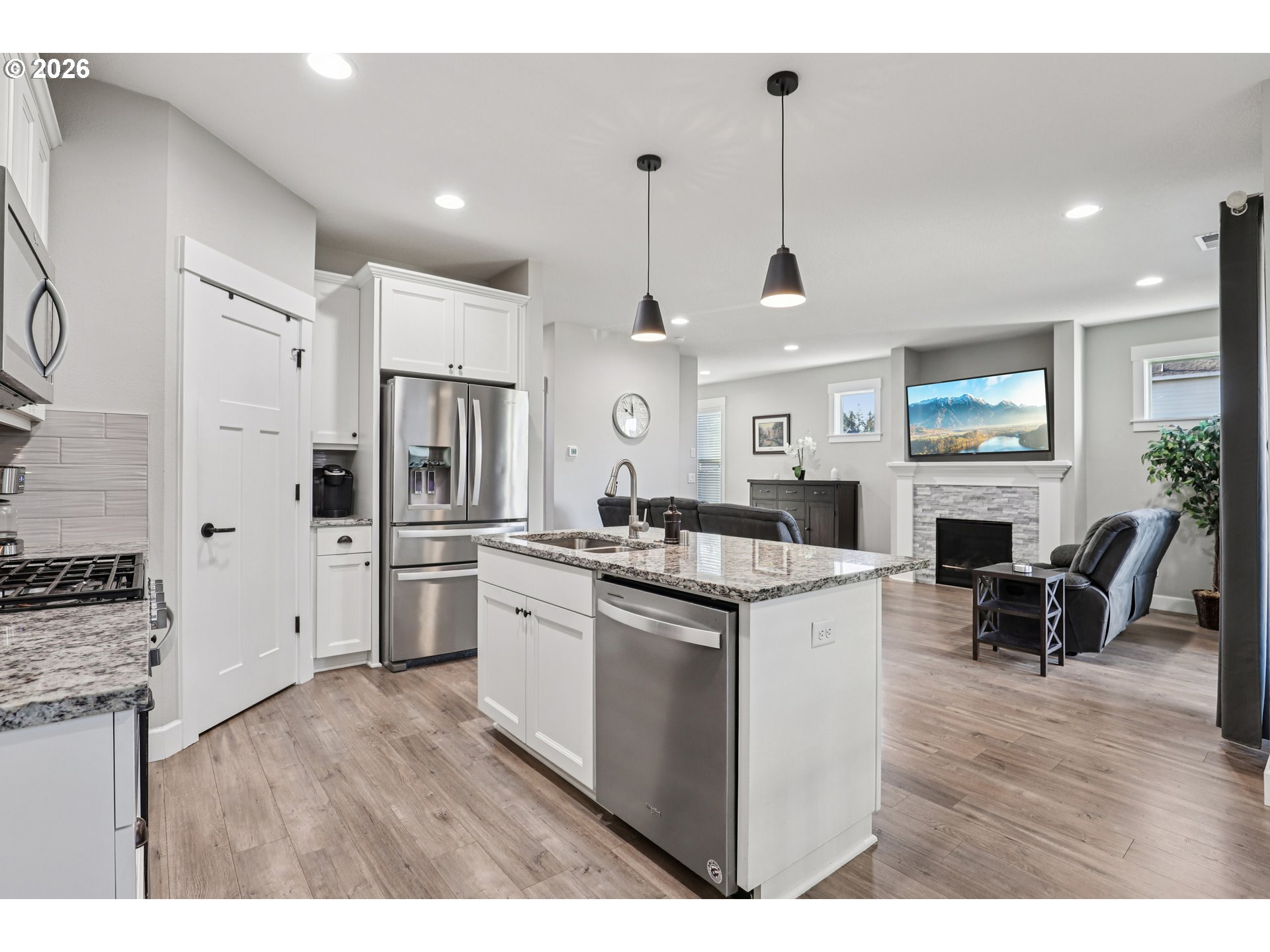 7346 South 13th Street Ridgefield, WA 98642 - Photo 11 of 38 a open kitchen with stainless steel appliances granite countertop a stove cabinets and wooden floor