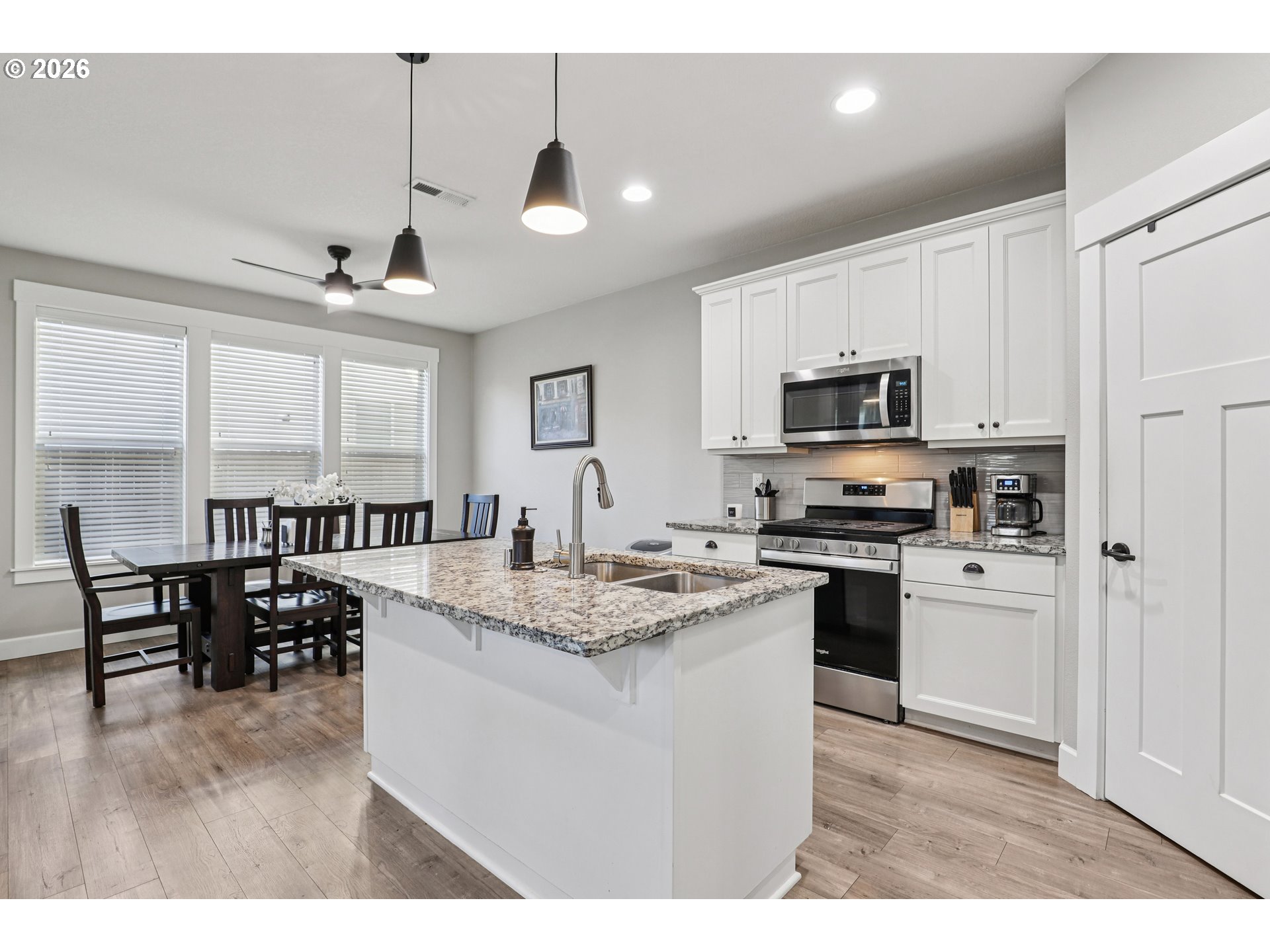 7346 South 13th Street Ridgefield, WA 98642 - Photo 13 of 38 a kitchen with stainless steel appliances granite countertop a stove top oven a sink a dining table and chairs