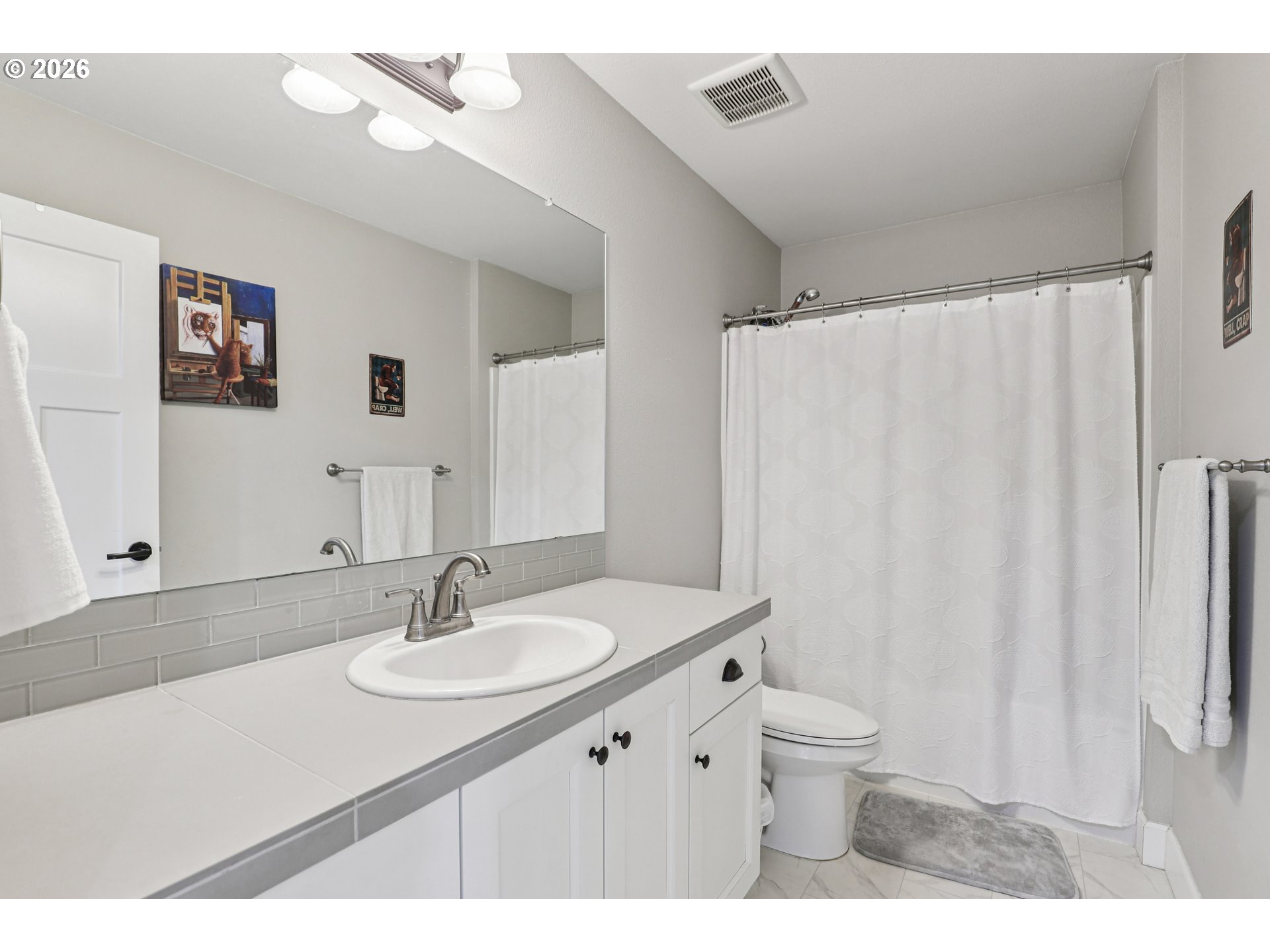 7346 South 13th Street Ridgefield, WA 98642 - Photo 19 of 38 a bathroom with a sink toilet a mirror and vanity