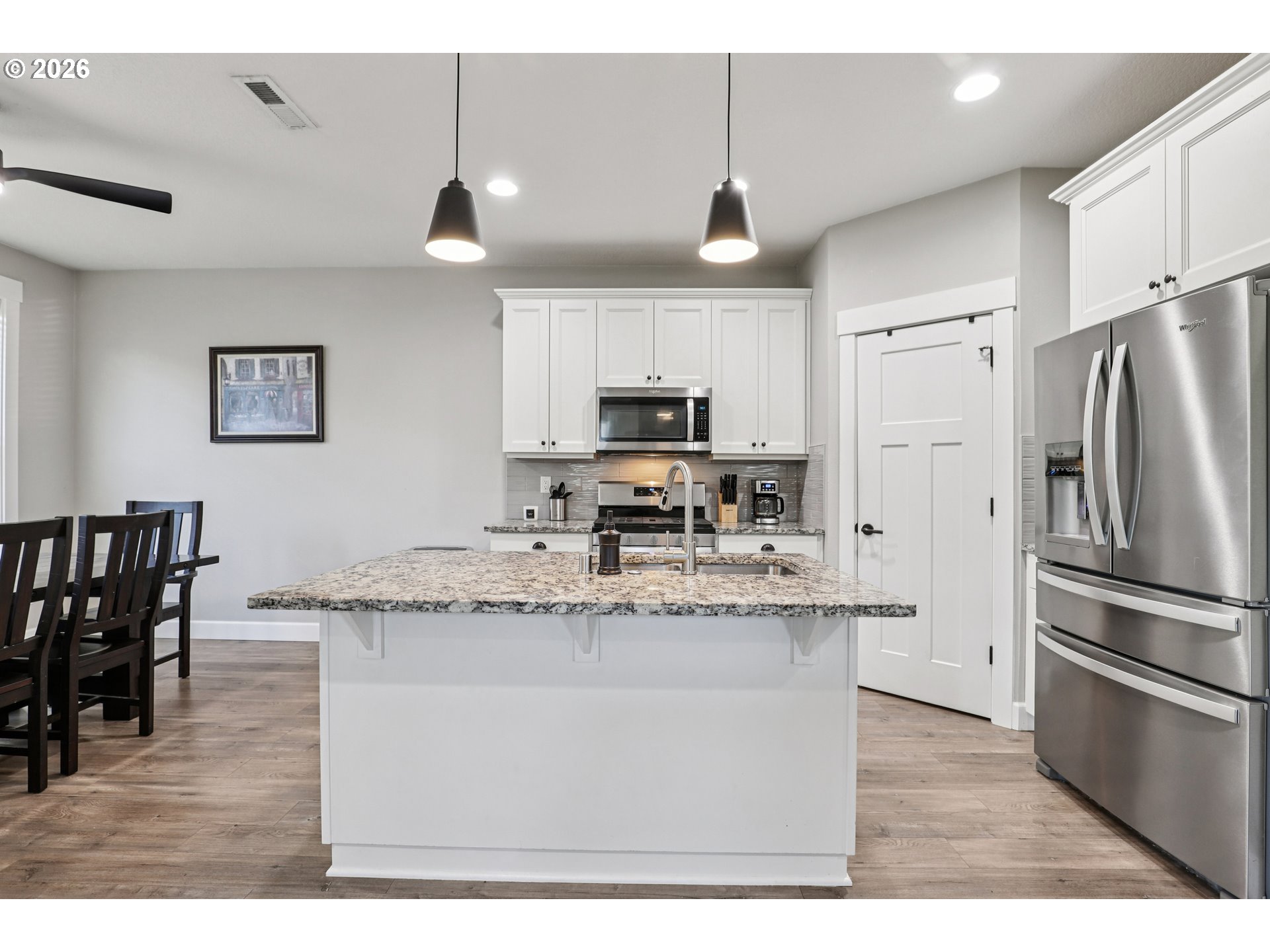 7346 South 13th Street Ridgefield, WA 98642 - Photo 9 of 38 a kitchen with stainless steel appliances granite countertop a sink a stove a refrigerator cabinets and chairs