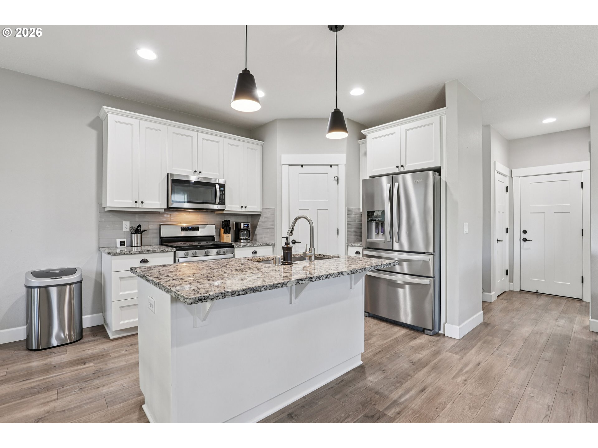 7346 South 13th Street Ridgefield, WA 98642 - Photo 10 of 38 a kitchen with stainless steel appliances granite countertop a refrigerator a stove a sink dishwasher a microwave oven with cabinets and wooden floor