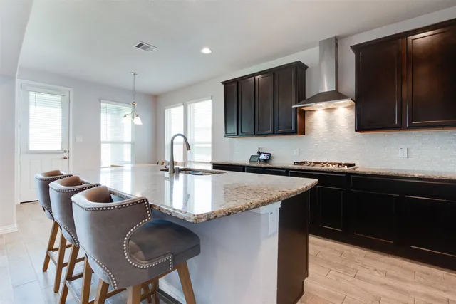 a kitchen with granite countertop a sink stove and refrigerator