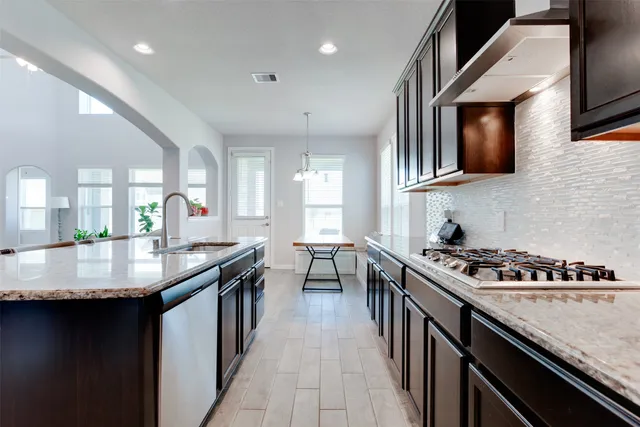 a kitchen with stainless steel appliances granite countertop a stove a sink and a microwave