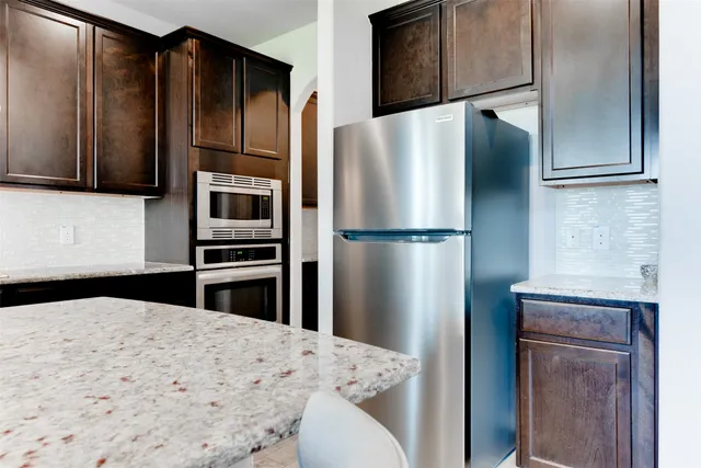 a kitchen with kitchen island a refrigerator and cabinets