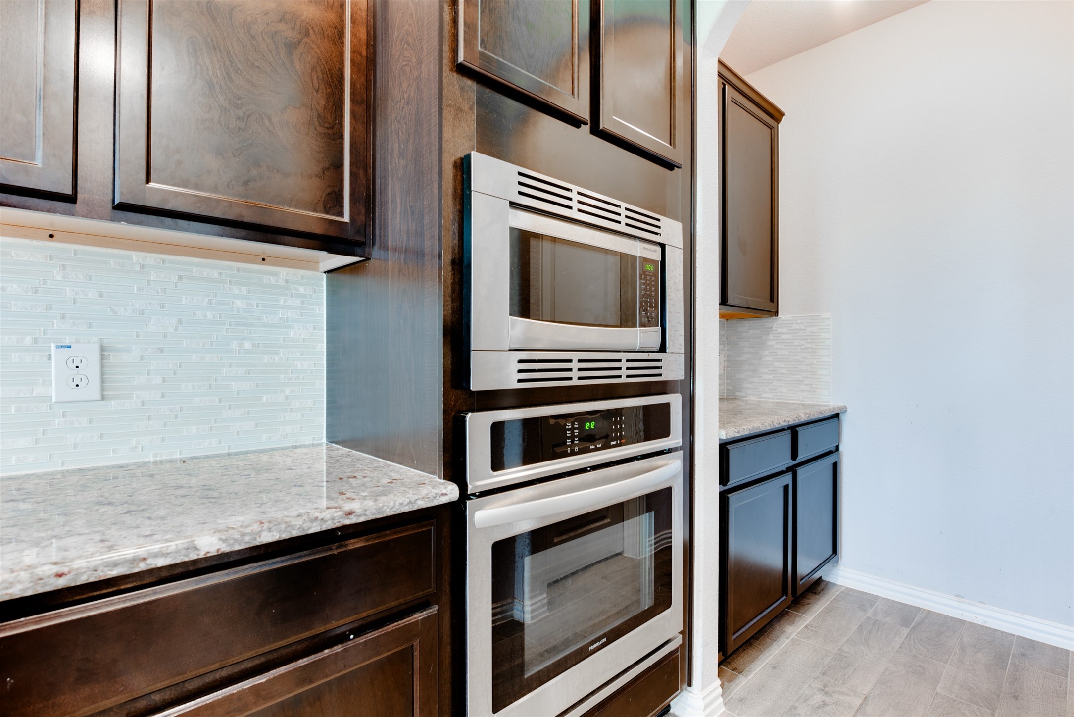 4310 Markstone Ridge Lane Rosharon, TX 77583 - Photo 16 of 40 a kitchen with wooden cabinets and a stove top oven