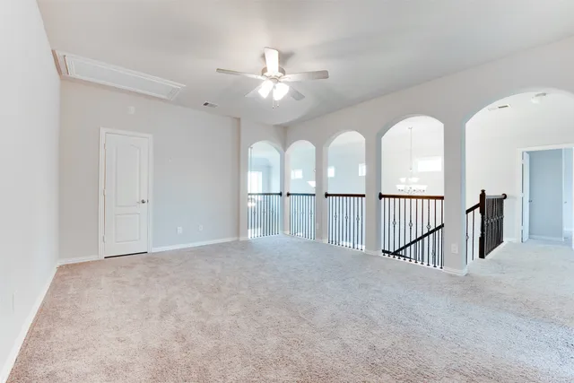 a view of a hallway with a chandelier fan and windows