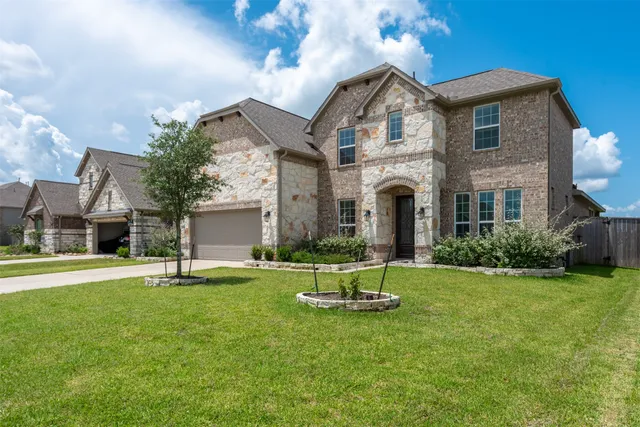 a front view of a house with a yard garage and outdoor seating