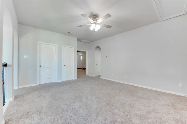 a view of an empty room with a ceiling fan